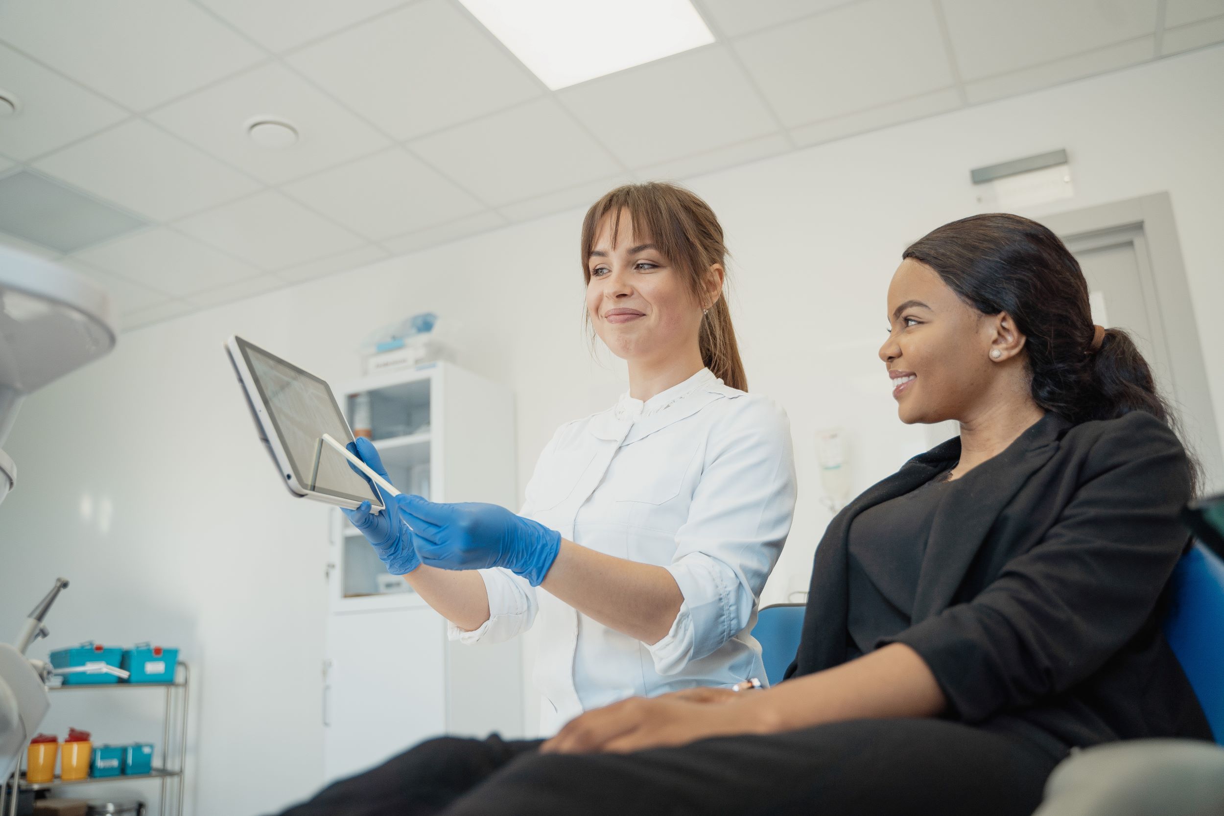 woman dentist showing xrays to patient sitting in dental chair